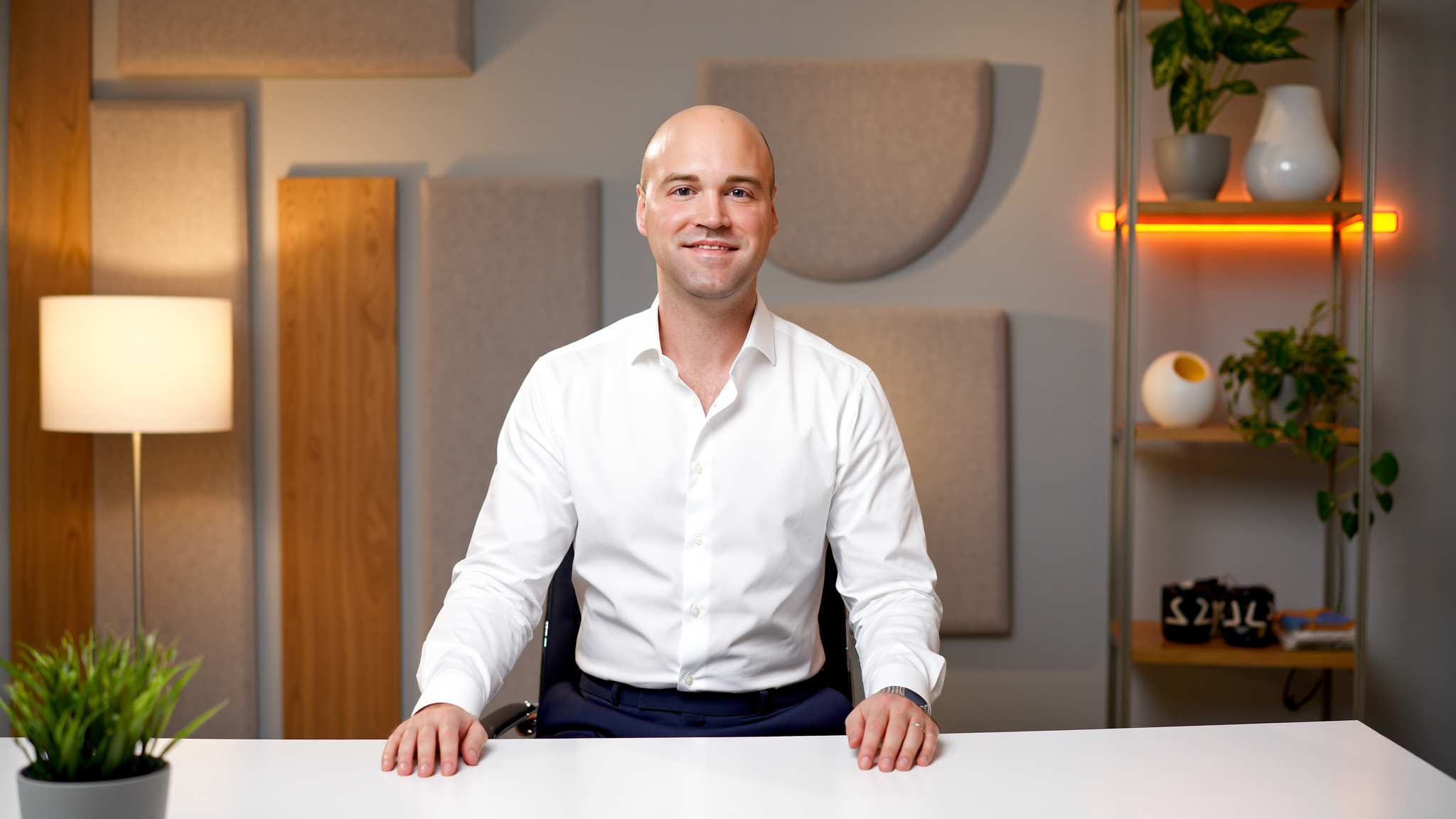 Jeremy Thomas seated at a desk in a studio portrait.